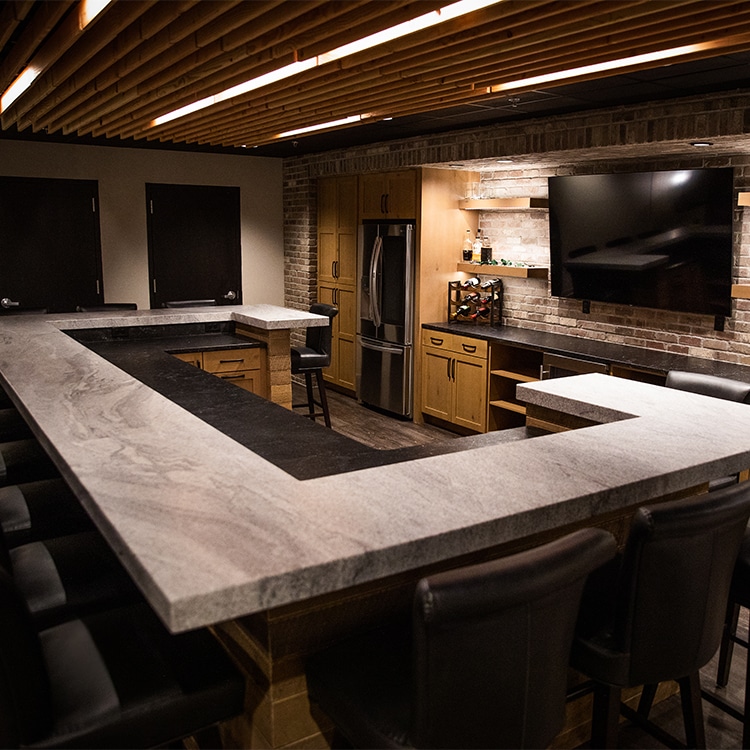 Wrap-around stone countertop in a home bar.