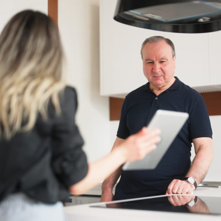 Home Industry professionals examining stone countertop in kitchen.